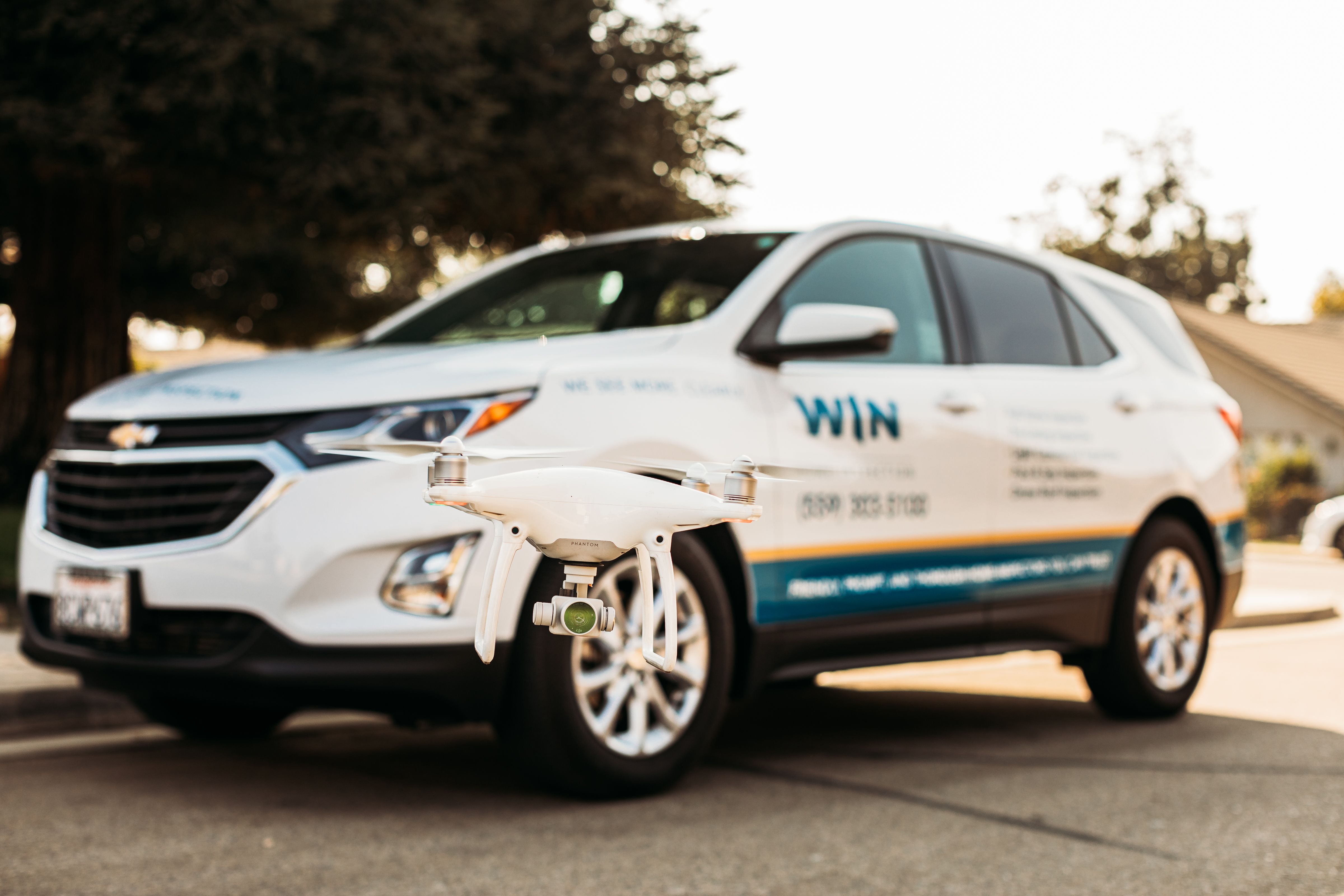 Drone in front of WIN Home Inspector's Car.